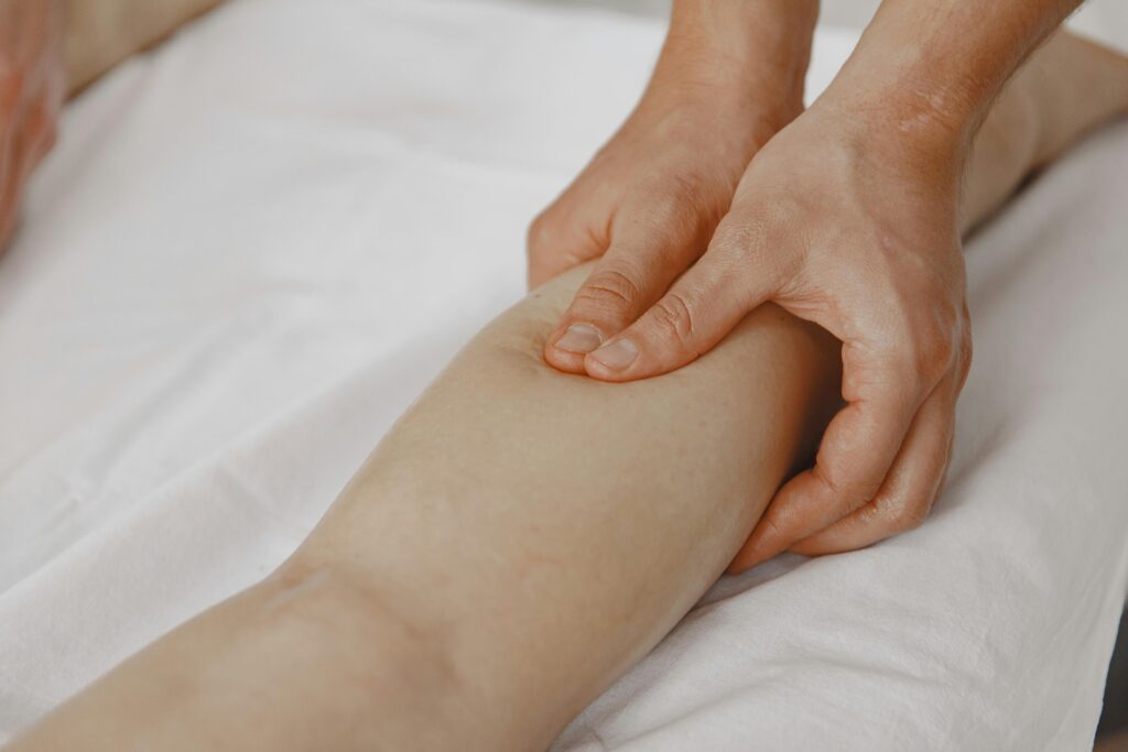 pexels-photo-5888064-5888064 Close-up image of a massage therapist applying pressure on a client's leg for muscle relaxation.